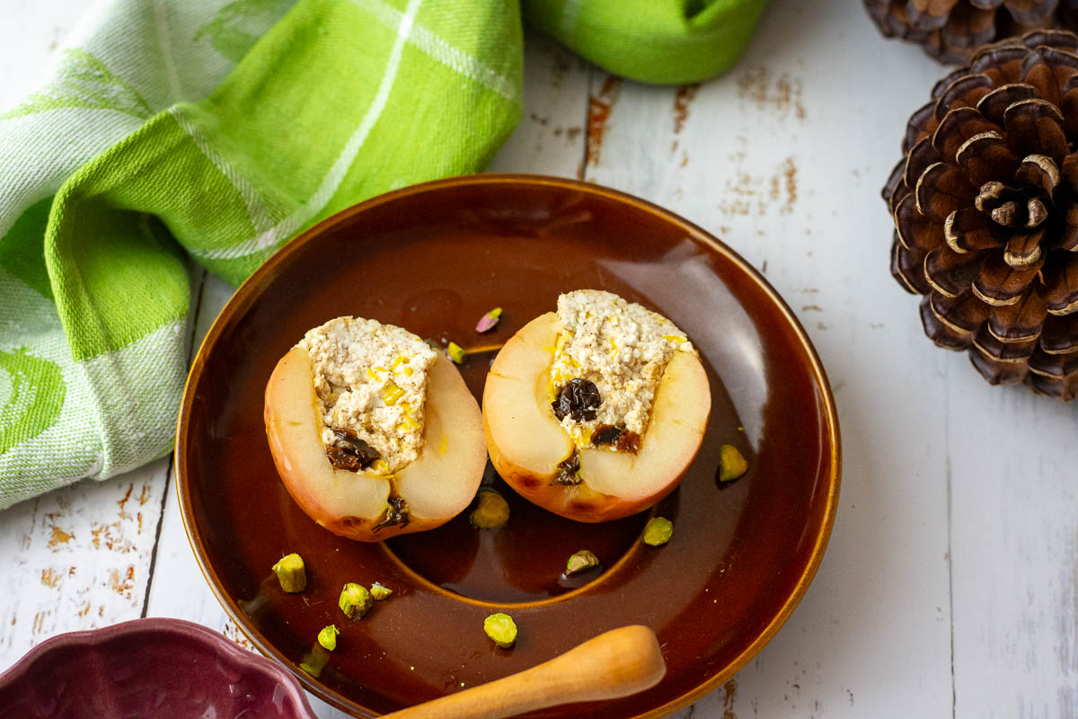 Lithuanian baked apple with farmer's cheese filing cut open on a brown plate.
