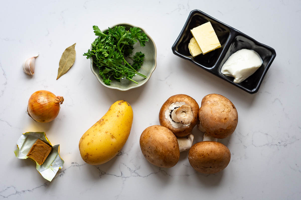 Ingredients for Lithuanian Mushroom and Potato soup on a light kitchen worktop. 