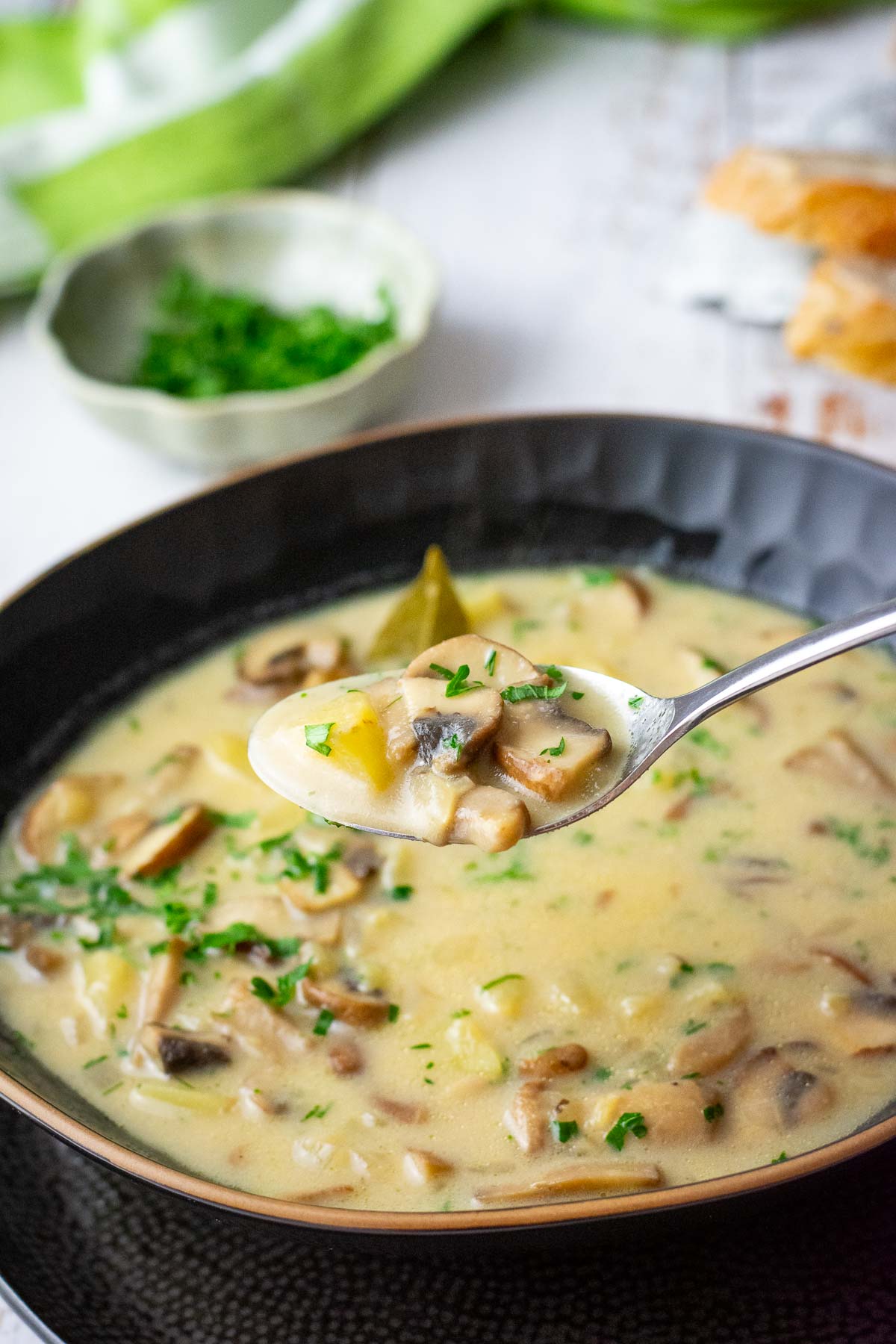 A spoonful of Lithuanian mushroom soup being taken out of a bowlful of it.