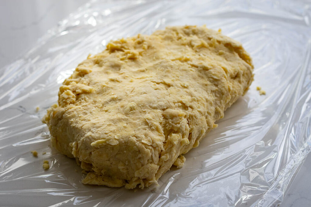 Cookie dough on a piece of plastic wrap.