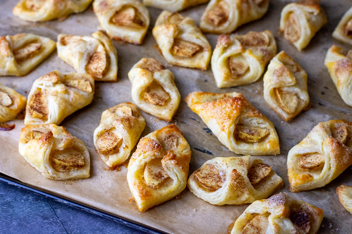 Lithuanian apple cookies, also known as Skarelės su obuoliais, on a baking sheet lined with parchment paper.