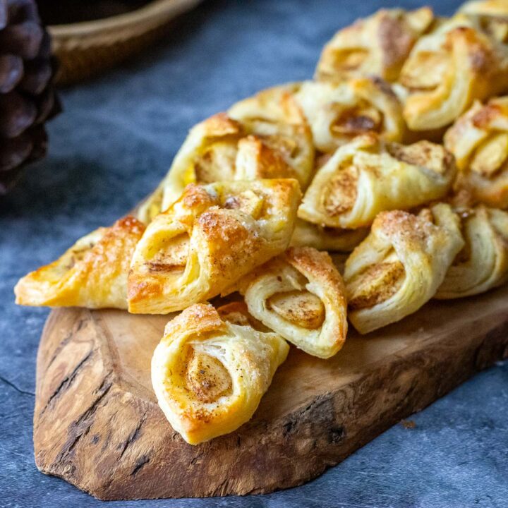 Lithuanian apple cookies, also known as Skarelės su obuoliais, arranged on a decorative wooden board.