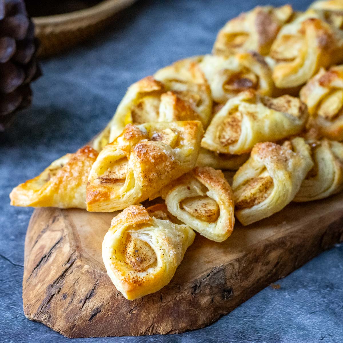 Lithuanian apple cookies, also known as Skarelės su obuoliais, arranged on a decorative wooden board.