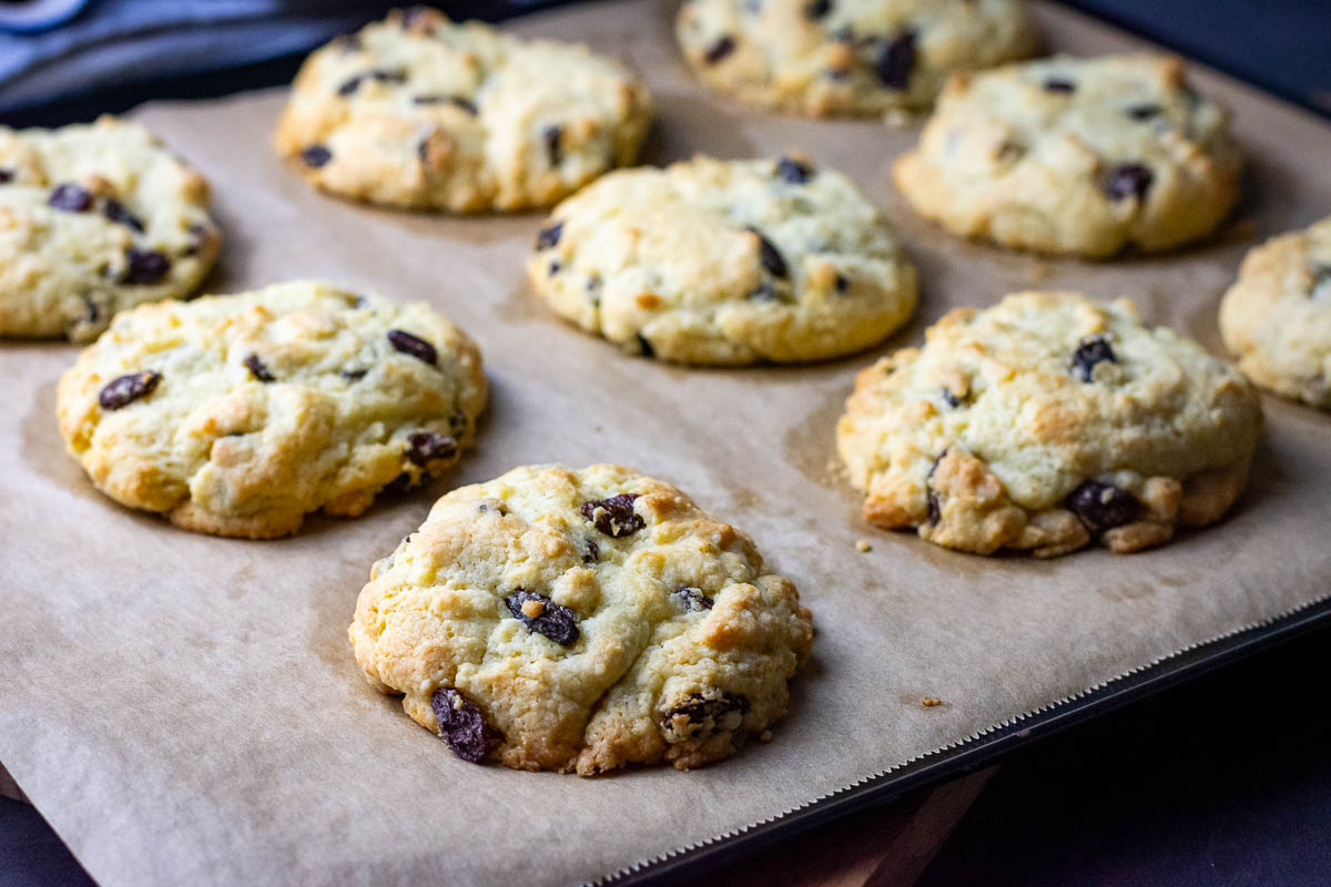 Lithuanian roksai with raisins that look like rocks, arranged on a baking sheet lined with parchment paper.